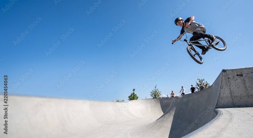 Fototapeta premium BMX Rider Performing Jump in Skatepark