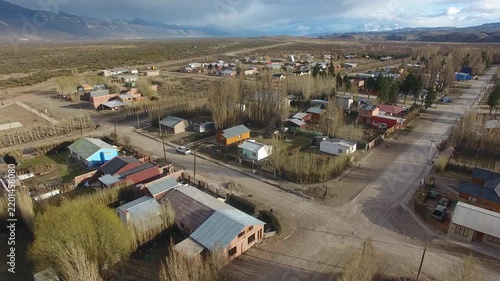 4K drone aerial view over Lago Posadas village in Santa Cruz, Argentina, revealing homes surrounded by rugged Patagonian landscapes, arid terrain and remote wilderness scenery.