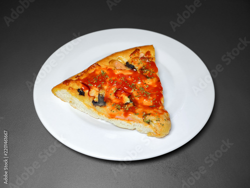 Pizza Slice with Red Chili Sauce, Vegetable, and Sausage on a White Plate. A Negative Space Available for Copywriting.