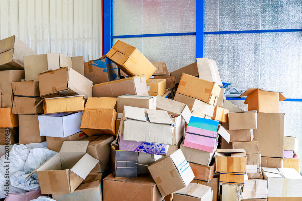 Fototapeta premium Stack of Cardboard Boxes in a Warehouse, Large pile of used cardboard boxes stacked in a storage area, packaging waste, paper recycling, waste sorting and sustainable resource management