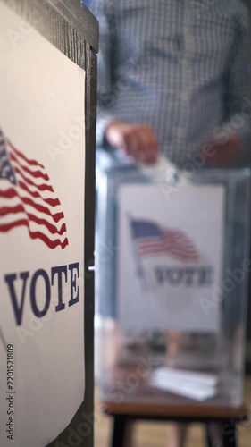 Midterm and presidential elections in USA, man voting at polling station with blurred background