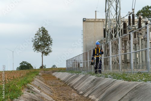Electrical technicians are inspecting the operation and power distribution system within the substation that receives energy from the wind farm.