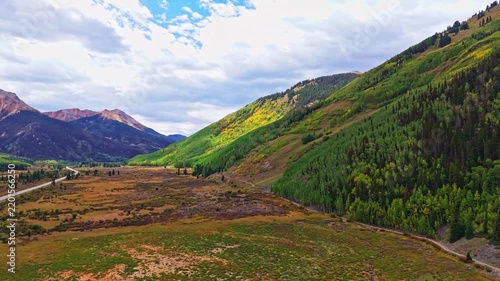 Aerial view of Red Mountain peaks overlooking golden autumn aspen forests near historic Ironton along Million Dollar Highway Colorado