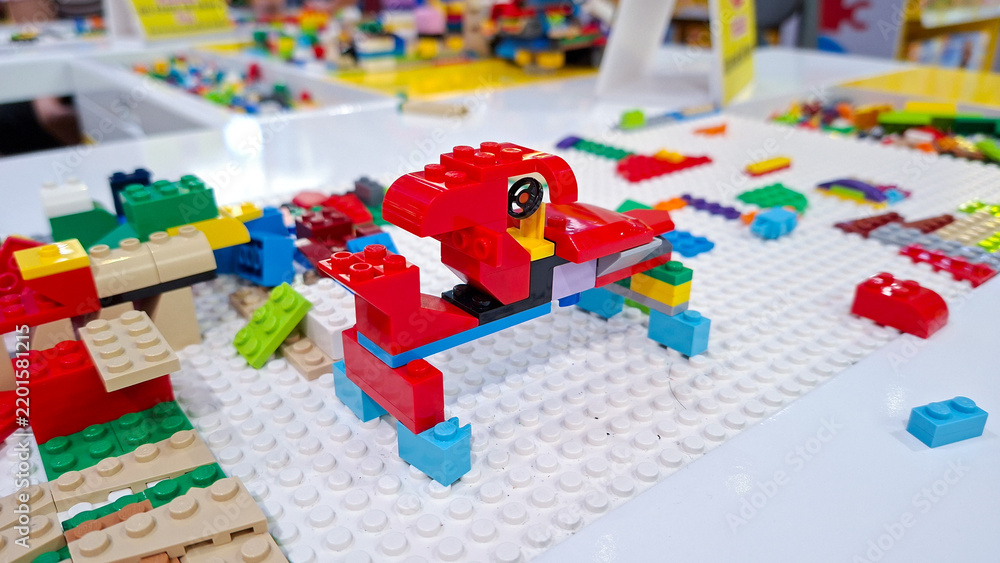 Obraz premium Red lego car vehicle built from plastic building blocks placed on white baseplate with colorful bricks on table play area on September 22, 2026 in Bangkok, Thailand.