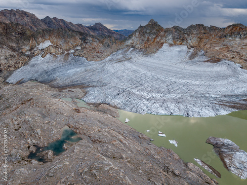 Glacier landscape with rocky mountains, frozen ice, and water bodies in the background, Austria