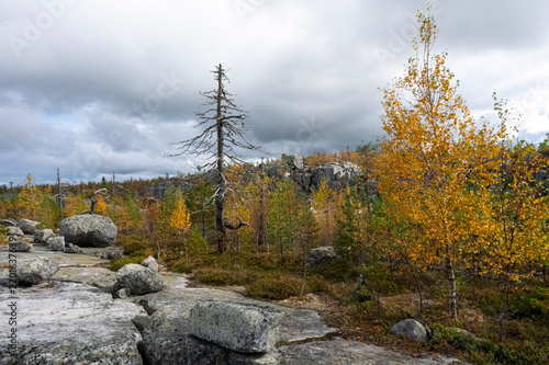 Autumn landscape with a rocky plateau under an impressive cloudy sky.
