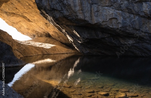 Obraz na płótnie 自然豊かな山あいの峡谷、緑の森に囲まれた公園で、旅行中に見つけた美しい風景。洞くつのある崖から落ちる川の水は、カスケードとなり優雅なフローを描いて流れます。ロックのあばたのある岩肌を濡らす湿気を感じながら、勢いよくとぶ滝の流れにナチュラルな癒やしを覚える、そんな瞬間を捉えた写真です。