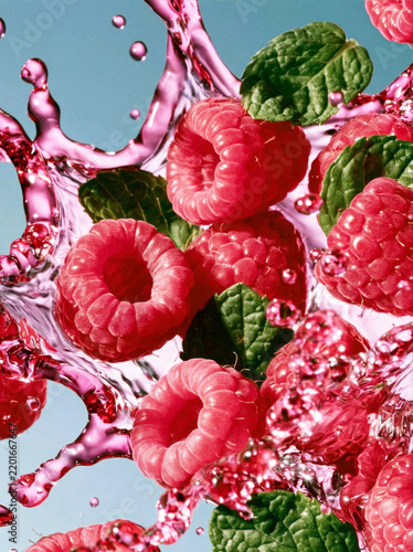 Fresh Raspberries with Mint Leaves Splashing in Water for Healthy Food and Beverage Concepts