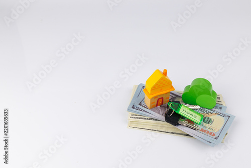 Cuadro en lienzo Close up view of a yellow toy house on US dollar banknotes and keys with a home