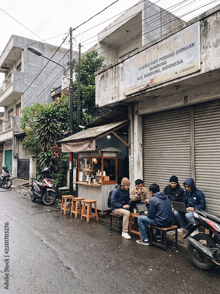 Obraz premium A group of friends enjoying coffee at an outdoor cafe on a rainy day