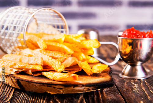 Crisp golden brown curly fried potato with rich red tomato dipping sauce close-up for snack or appetizer