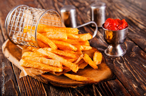 Crisp golden brown curly fried potato with rich red tomato dipping sauce close-up for snack or appetizer