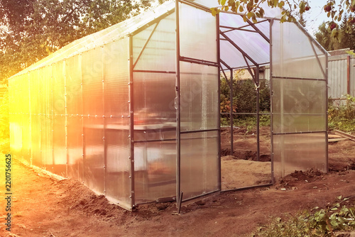 vGreenhouse built in a garden with framing and panels in a rural area during daylight