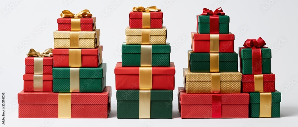 Obraz premium Five stacked piles of wrapped christmas gift boxes in red green and gold on white background