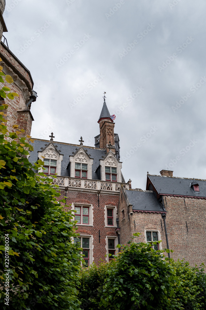 Obraz premium Bruges historic brick building with tower and cloudy sky