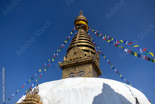 Swayambhunath Stupa and Radiating Prayer Flags Against Deep Blue Sky