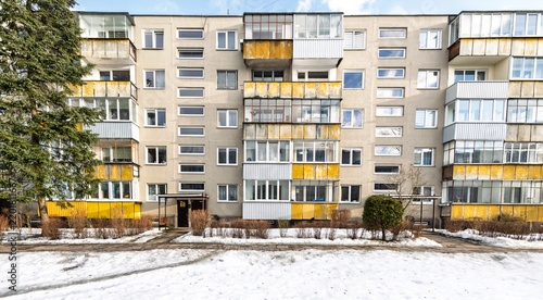 Soviet-Era Apartment Block With Yellow Balconies And Snowy Front Yard In Winter City