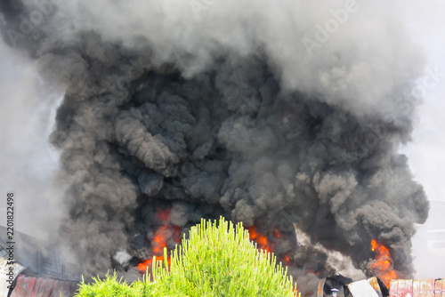 Industrial building fire creating thick toxic black smoke