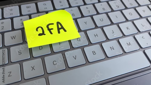 Two factor authentication sticky note on laptop keyboard