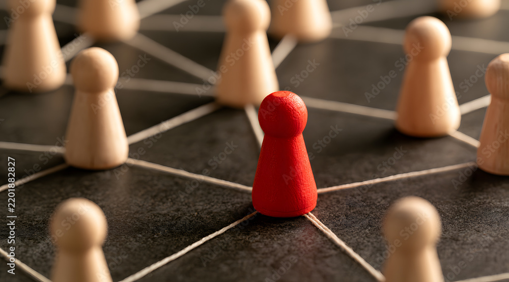 Obraz premium The central figure made of red wood, which forms part of a linked system, symbolizes leadership and the organization's social structure.