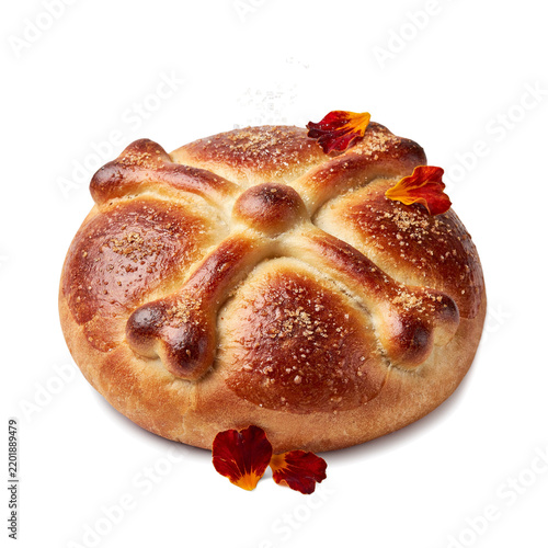 Traditional Mexican Pan de Muerto sweet bread sprinkled with sugar and bone cross decorations for Day of the Dead   