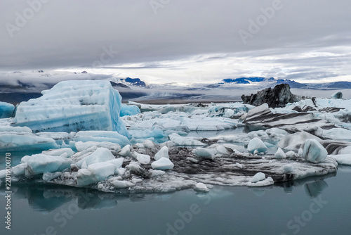 Panoramic view. National Park with calm water, large blue icebergs or melting ice. Jökulsárlón or 
