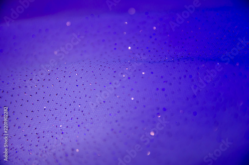 A delicate dark background. A screen saver with fabric. A festive decoration. Light and bokeh. Purple and blue colors. A greeting card for a wedding, engagement, or March 8.A template and copy space