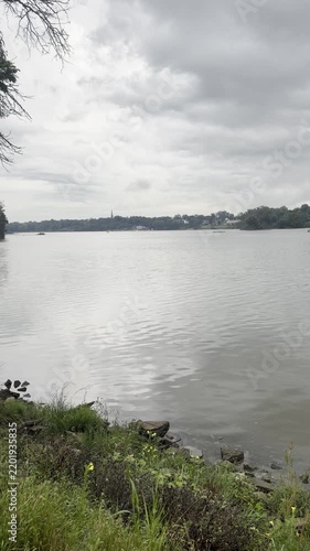 scenic view of a wide calm river under an overcast cloudy sky