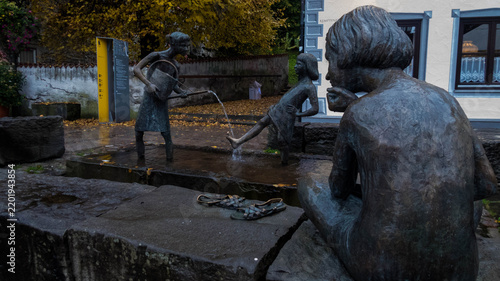 Bronze fountain statues depicting children playing with water in Füssen old town, Bavaria, Germany