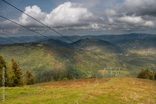 Ski lift cables above a green mountain landscape