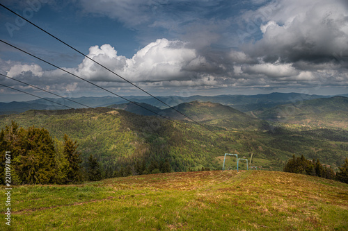 Ski lift cables above a green mountain landscape