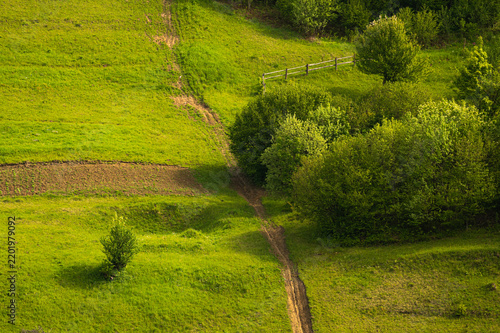 Rural meadow with haystack and winding dirt path