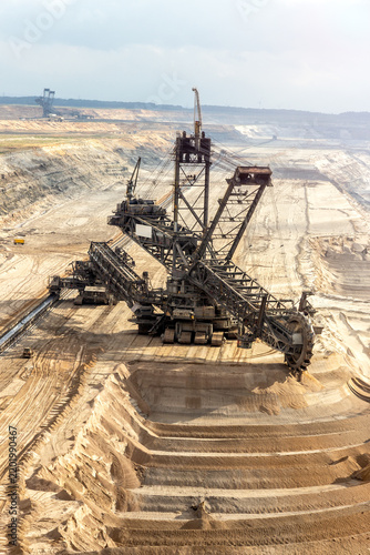 Bucket-wheel excavator mining brown coal in a large open-pit mine. The massive mining machine is used for surface extraction of lignite.