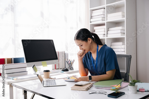 Exhausted Nurse at Desk: A healthcare professional with tired eyes and a slumped posture sits at a cluttered desk, head in hand.
