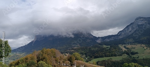 Fotografie n impressionnant paysage de montagne enveloppé de nuages, au-dessus d'une vallée