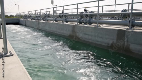 Operational industrial water treatment plant, featuring active purification processes in concrete channels, crucial for sustainable resource management and environmental well-being