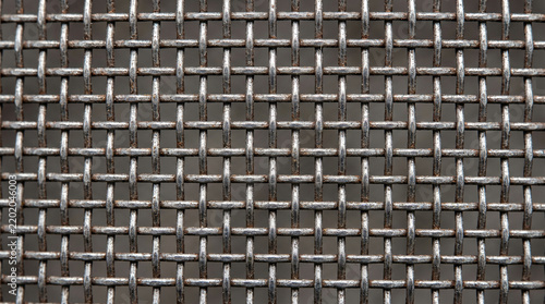 Close up of a metallic wire mesh screen with a repeating square grid pattern and industrial texture