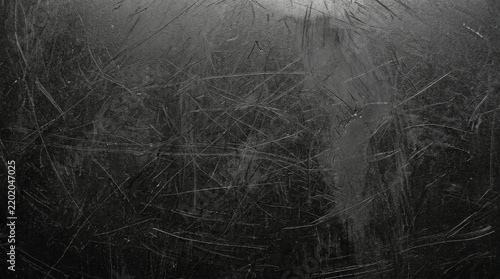 Dark scratched metal surface texture with distressed industrial finish and subtle light reflections