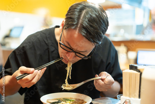 Fototapeta ラーメンを食べる男性