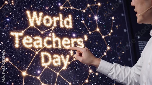 A person points at a glowing 'World Teachers' Day' text displayed on a dark, starry background with constellation-like connections.