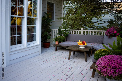 Cozy fall patio with outdoor seating, colorful chrysanthemums and fresh fruit