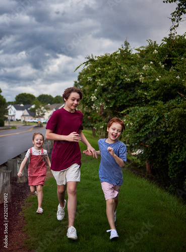 Happy children laughing and running together in warm summer rain