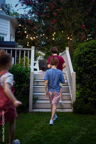 Rear view of children heading home after playing outside on a cozy summer evening