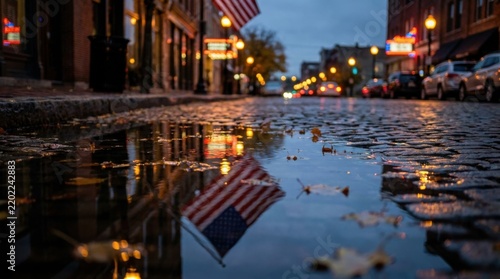 Wet City Pavement at Night with Rain Puddle Reflecting American Flag