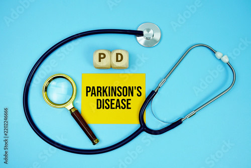 Konstfotografi Parkinson's Disease (PD) text with stethoscope and magnifying glass on blue back