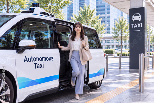 自動運転タクシーから降車する日本人女性