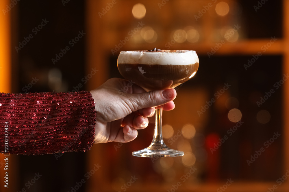 Fototapeta premium Woman holding glass of tasty tiramisu cocktail in bar
