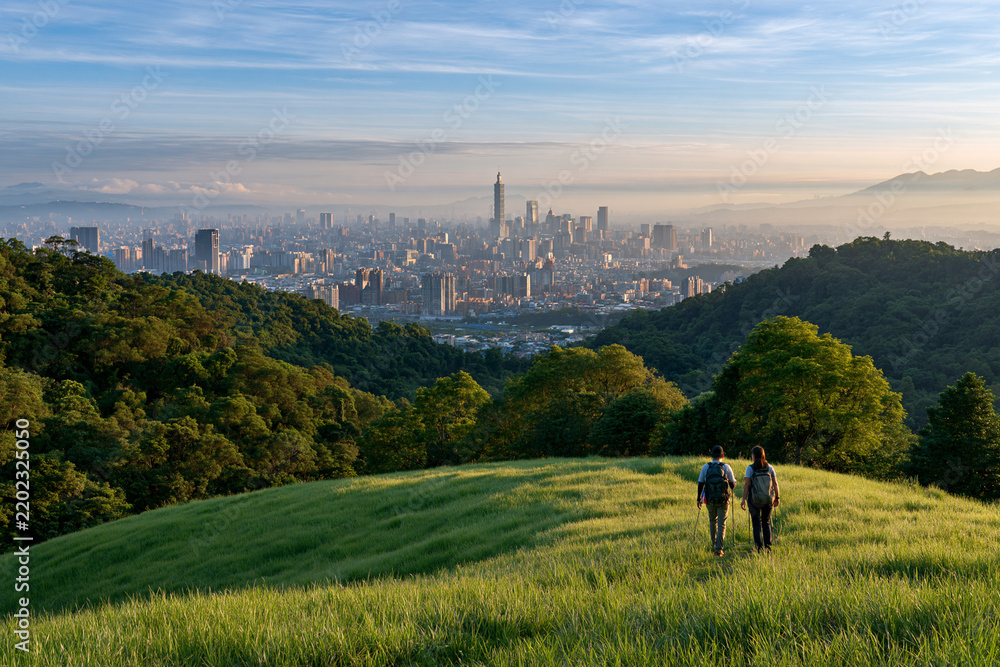 Obraz premium Hikers overlooking Taipei city in morning haze