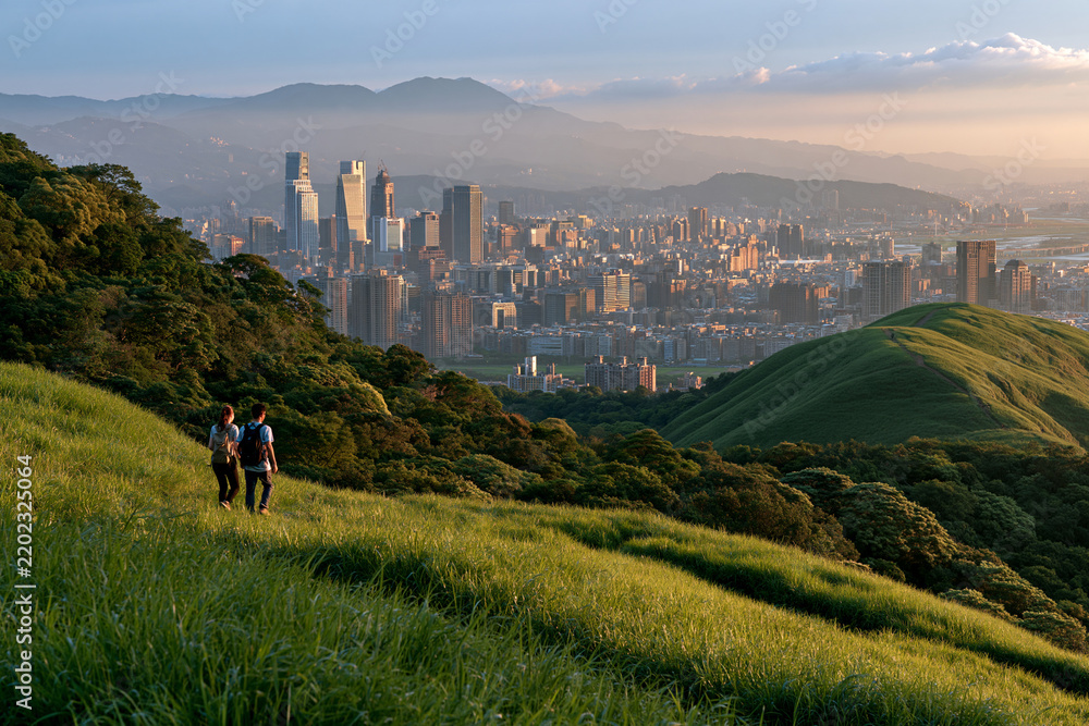 Obraz premium Hikers overlooking Taipei city in morning haze