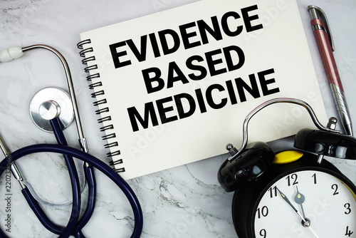 Evidence Based Medicine text written on notepad with stethoscope and alarm clock on marble background